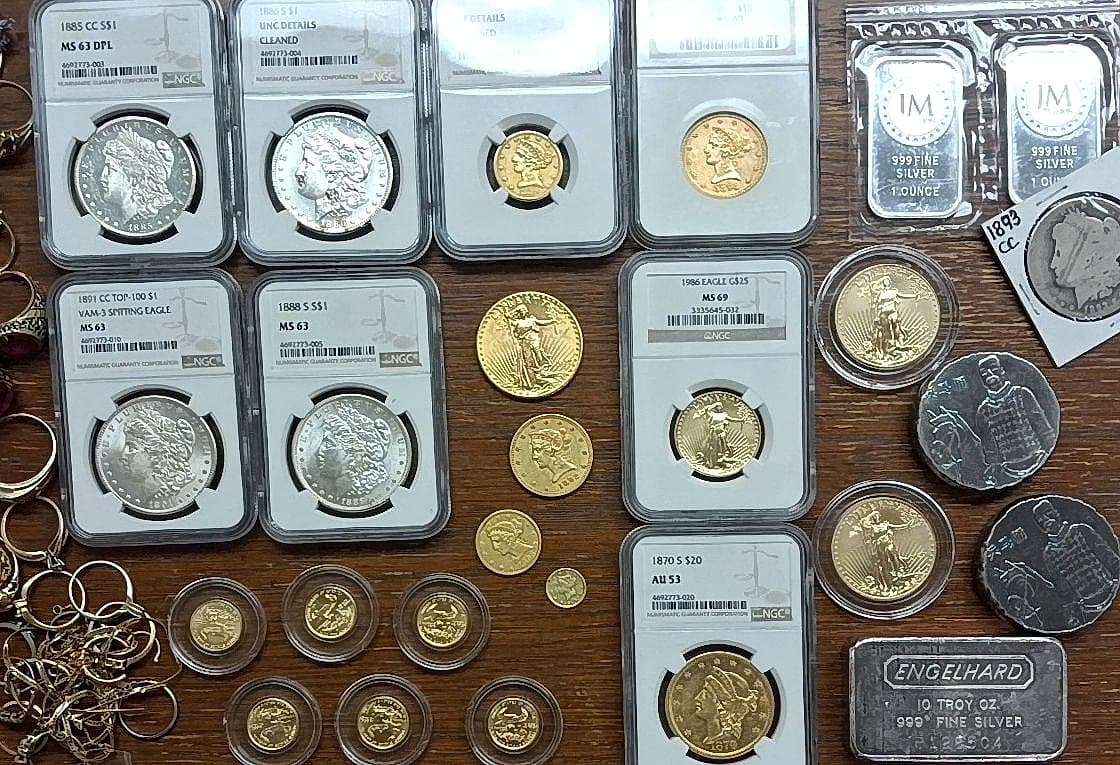 Certified Morgan dollars, gold eagles, and silver bars laid out during an appraisal